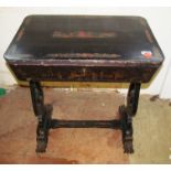 A 19th century ebonized work table with chinosserie scenes and claw feet fitted with lidded