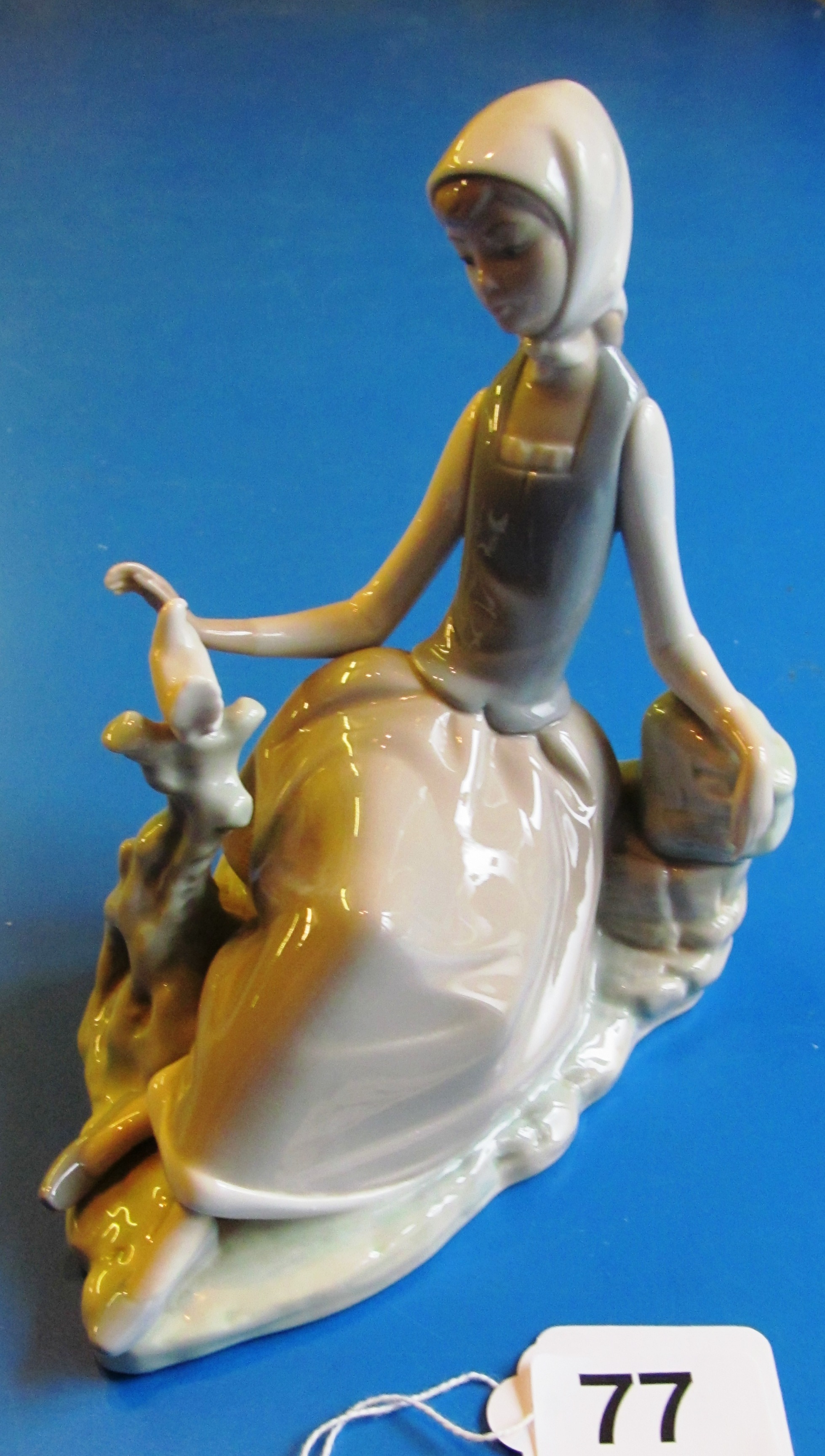 A Lladro seated lady with bird.