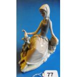 A Lladro seated lady with bird.