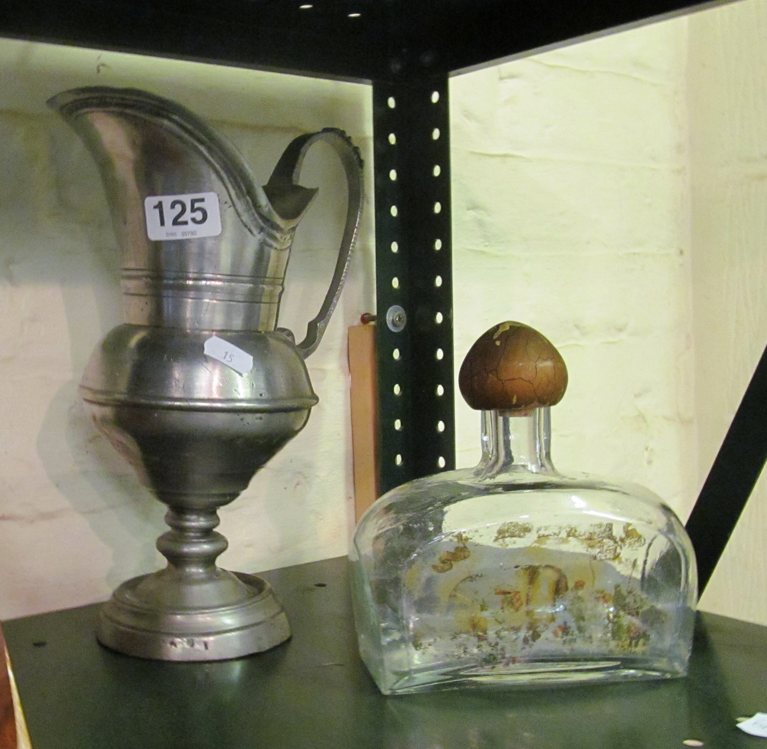 A pewter jug and a glass bottle flask