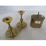 A brass tea caddy and a pair of brass candlesticks with pierced sconces