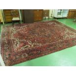 A large Persian style carpet red ground and floral pattern