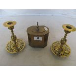 A brass tea caddy and a pair of brass candlesticks with pierced sconces