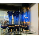 A tall blue glass vase, two blue spill vases and five sundae dishes.