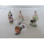 A Chelsea style figure fruit seller, a pair of figures 18th Century lady and gent with dogs, and a