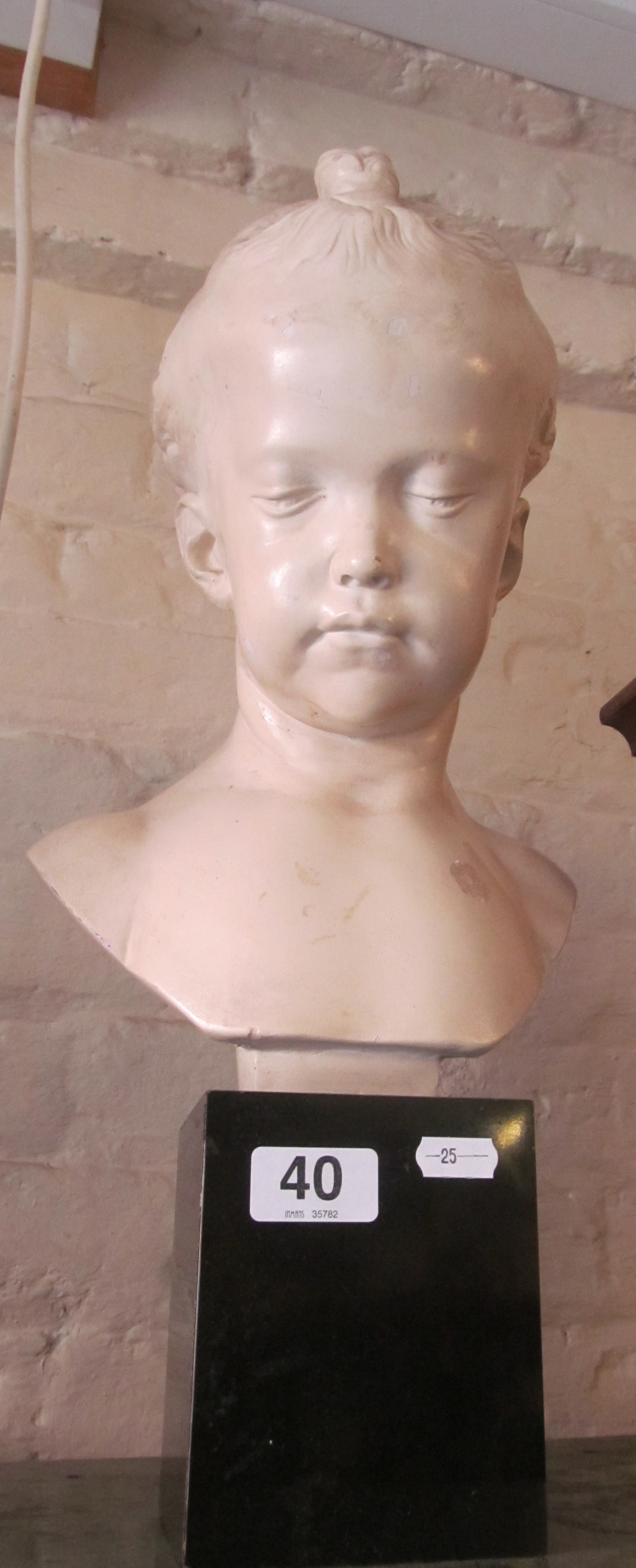 A plaster bust of a young girl