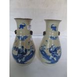 A pair of oriental crackle ware vases with blue and white design of man with leaf branch and