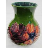 A Moorcroft vase of green ground, pink and purple flowers.