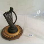 An Irish bog oak carved model of a harp under glass dome.