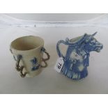 A tin glazed earthenware four handle mug bearing date 1612, and cow creamer.