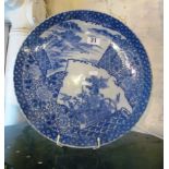 A late 19th Century Japanese blue and white plate, reserves of landscapes, flowers and birds.