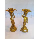 A pair of gilt cherub candlesticks with lustre drops