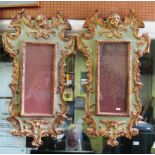 A pair of Venetian style green and gilt painted mirrors with cherub surmounts