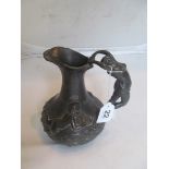 A French pewter jug with semi-naked lady on handle and two cherubs on woodland floor, marked Etain