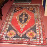 A 170cm x 110cm - Turkish rug with red and blue centre medallion, geometric border