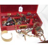 A leather box containing costume jewellery, including brooches