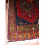 A 235cm x 125cm Turkish rug with red/blue ground