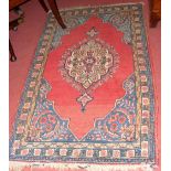 A 145cm x 85cm Middle Eastern rug with red ground