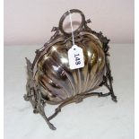 A silver plated ornately cast plate warmer in the form of a scallop shell with a ring handle