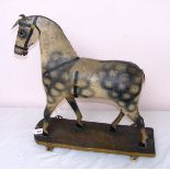 A late Victorian / early 20th century paper mache horse pull toy on wheels,measuring 21" tall.