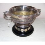 A large twin handled silver plated trophy free from inscription freely standing on a ebonised
