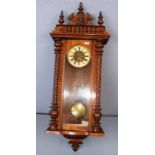 A large mahogany Vienna wall clock with twisted columns with a carved figural central finial and