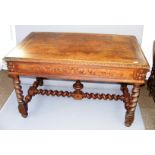A Victorian heavily carved oak table in the Gothic style with barley twist legs,