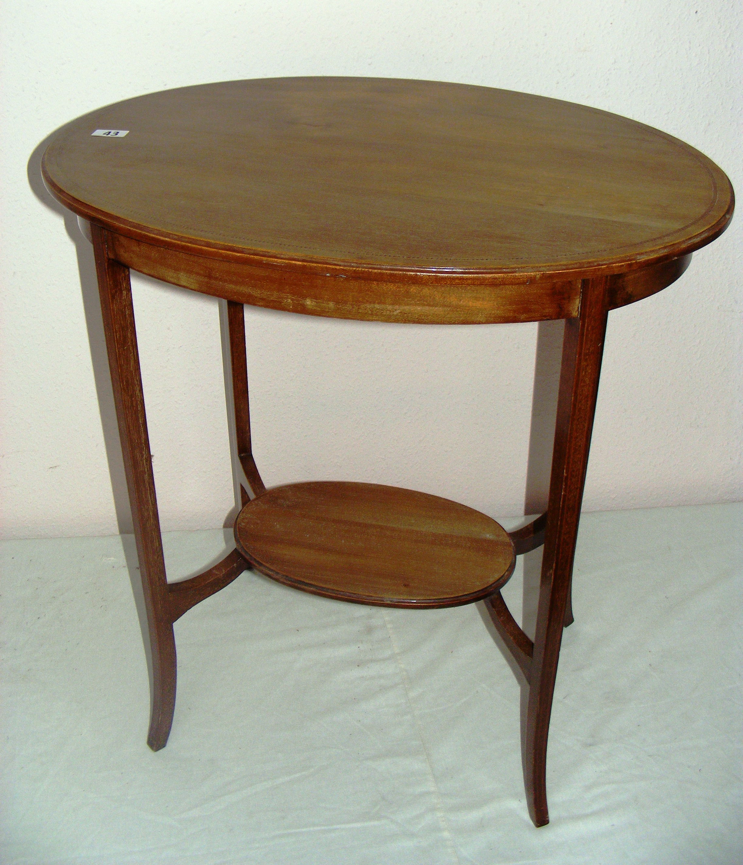 Edwardian, a mahogany two tiered oval inlaid hall table, measuring 26" wide.