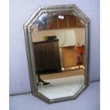 A wall mirror, with a pewter frame in the Arts and Crafts style, measuring 33.5" tall.