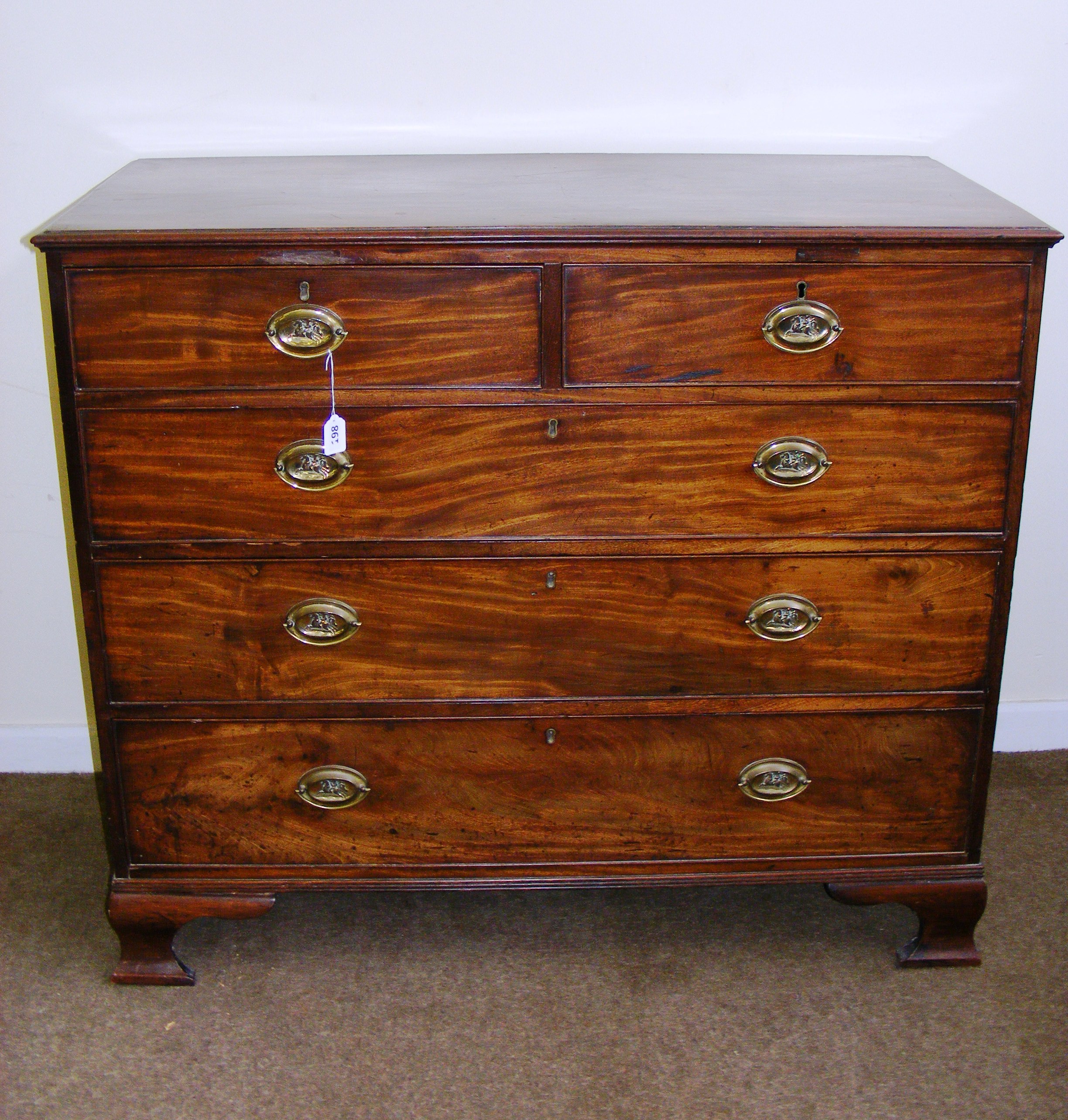 A Georgian two over three mahogany chest of drawers with decorative brass handles on four feet (one