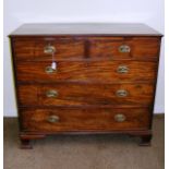 A Georgian two over three mahogany chest of drawers with decorative brass handles on four feet (one