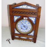 A mantle clock, made from carved oak, measuring 17.5" tall, with a blue floral style dial.