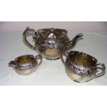 A silver plated three piece tea service with floral decoration .