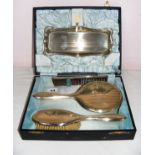 A silver plated four piece dressing table set in a fitted case.