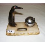 An Art Deco style desk ink stand with a carved penguin figure on an onyx base measuring 6.5" wide.