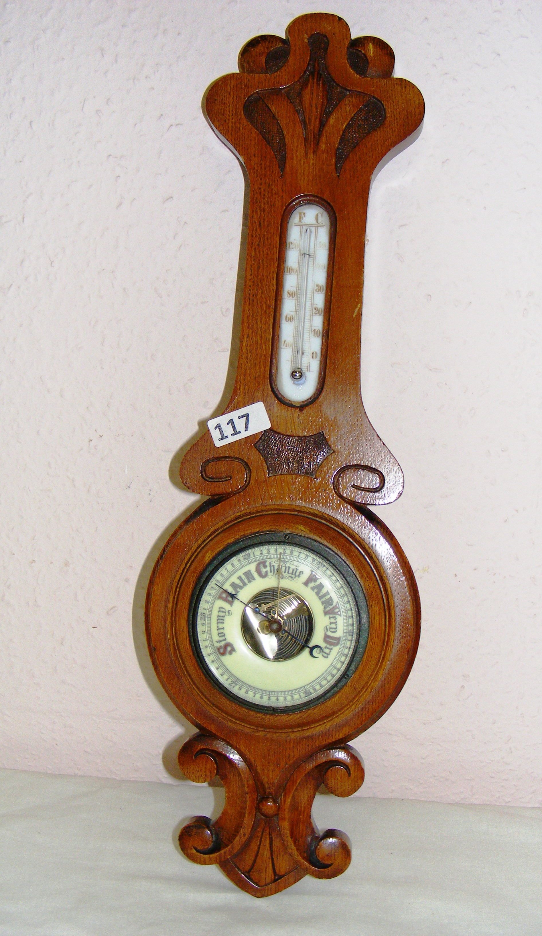 A mid 20th century oak cased banjo barometer measuring 21.5" long.