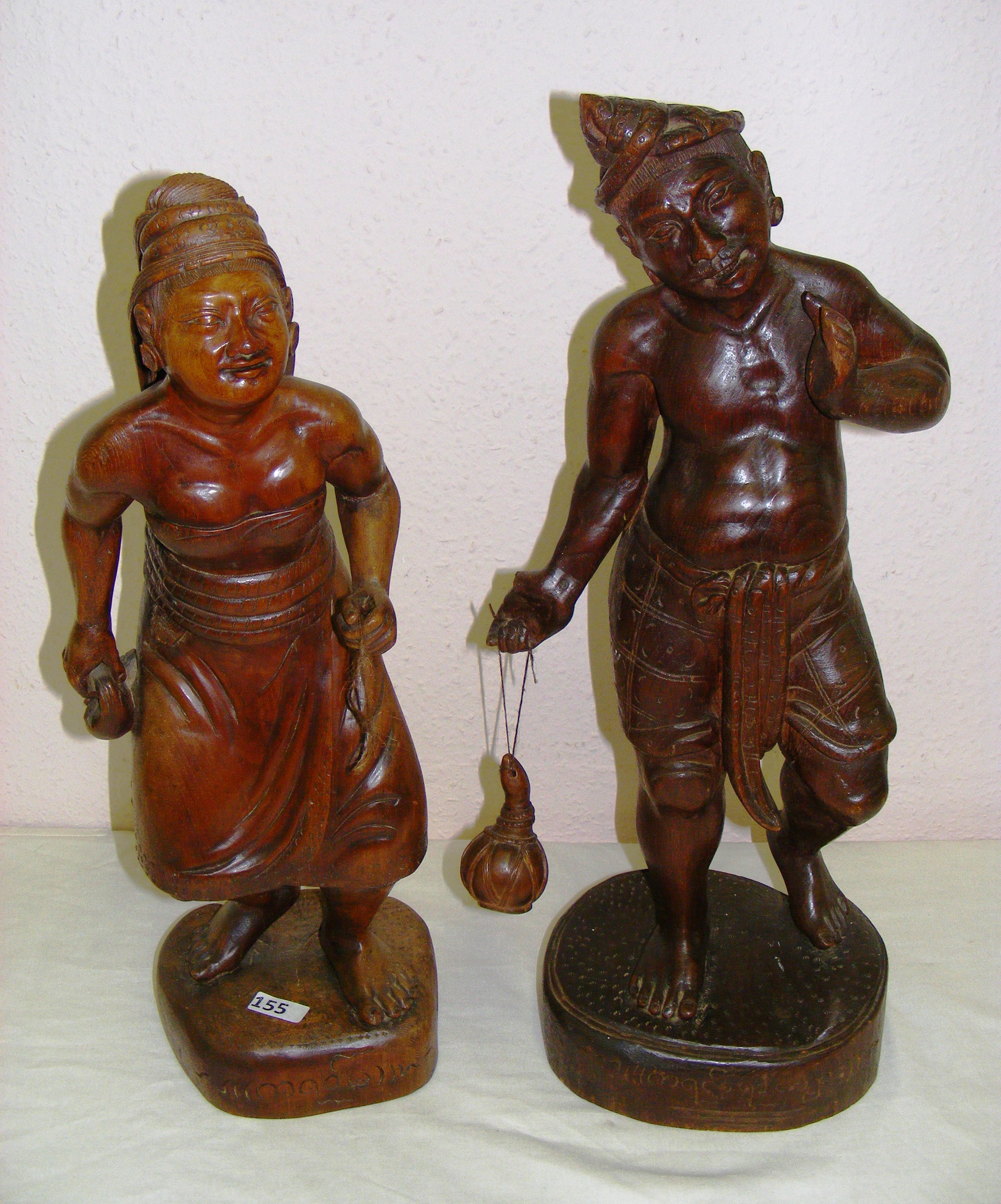 A pair of Indian carved hardwood figures of a man and woman each measuring 23" tall.