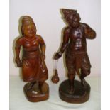 A pair of Indian carved hardwood figures of a man and woman each measuring 23" tall.