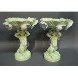 A Pair of Continental Porcelain Comports, each with figural support upon a circular base,