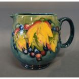 An Early Moorcroft Large Jug, tube lined with leaves and berries upon a mottled blue ground,