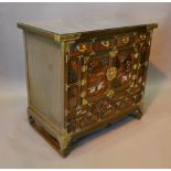 A Japanese Lacquered Side Cabinet with an arrangement of drawers and doors raised upon low feet,