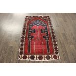 A North West Persian Woollen Rug with an all over design upon a red and blue ground within multiple