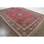 A North West Persian Woollen Carpet, with a central medallion amongst an all over design upon a red,