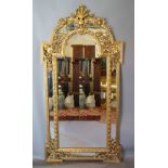 A Large Gilt Framed Sectional Wall Mirror with arched carved cresting and pierced carved corner