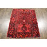 A North West Persian Woollen Rug with an all over design upon a red and blue ground within multiple