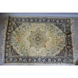 A North West Persian Woollen Rug with a central medallion upon a cream and blue ground within