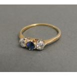 An 18ct Yellow Gold and Platinum Sapphire and Diamond Ring with a central sapphire flanked by