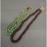 A Jade Bead Necklace together with another similar garnet necklace