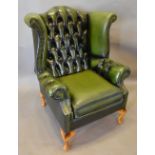 A Green Leather Button Upholstered and Studded Wingback Armchair with cabriole legs