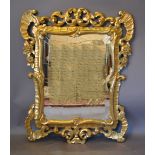 A Carved Giltwood Wall Mirror with a pierced ribbon frame,